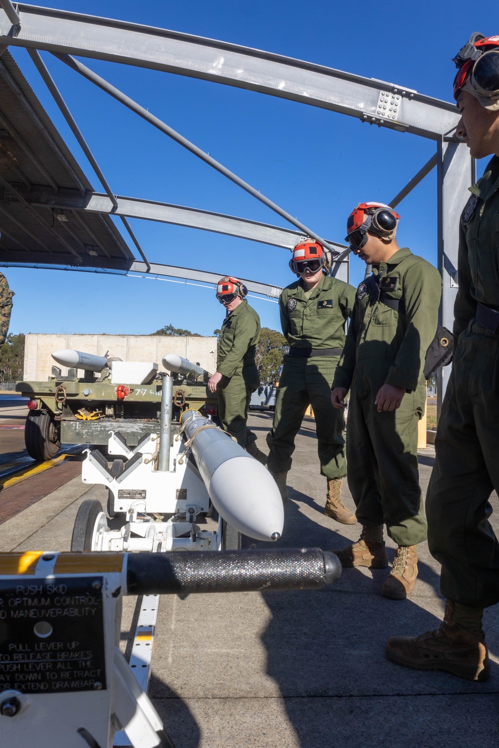 U.S. Marines and Australian Airmen load Missiles on Joint Strike Fighters together  