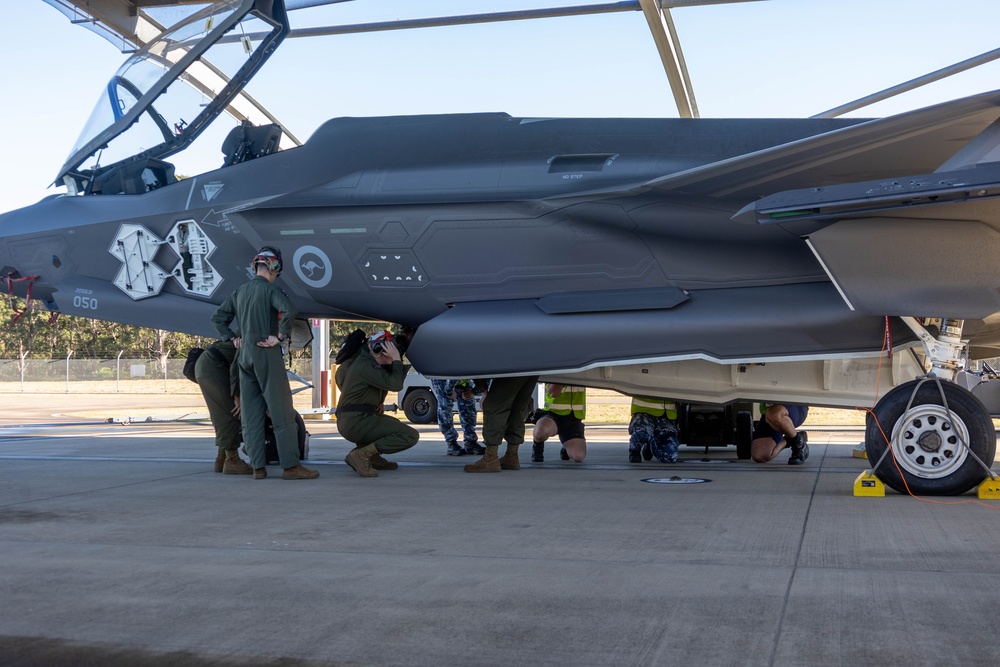 U.S. Marines and Australian Airmen load Missiles on Joint Strike Fighters together  