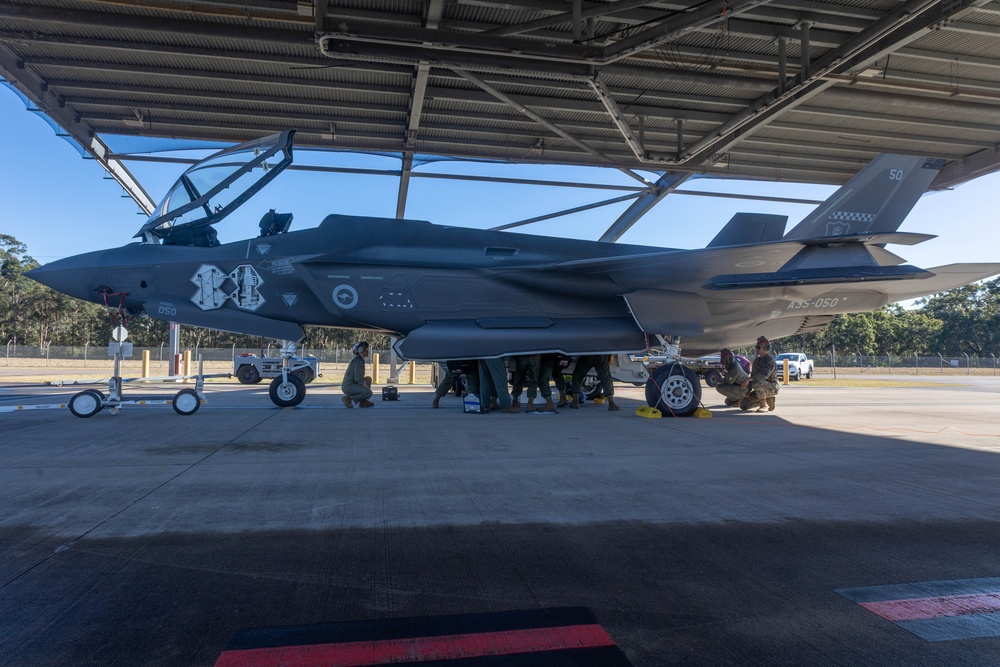 U.S. Marines and Australian Airmen load Missiles on Joint Strike Fighters together  