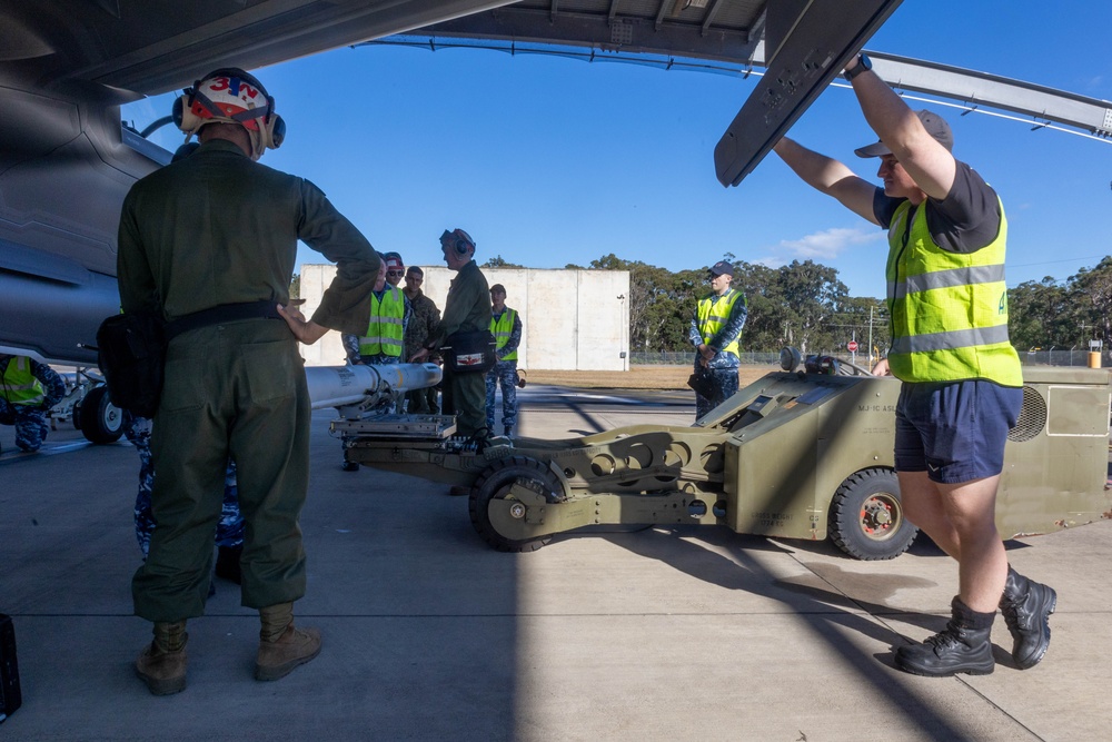 U.S. Marines and Australian Airmen load Missiles on Joint Strike Fighters together  