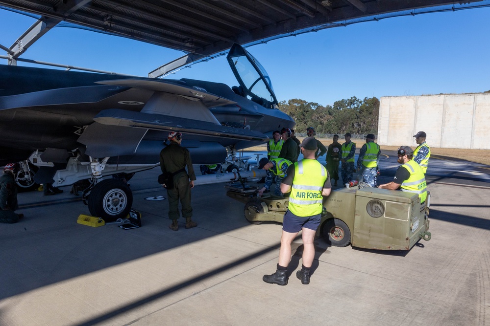 U.S. Marines and Australian Airmen load Missiles on Joint Strike Fighters together  