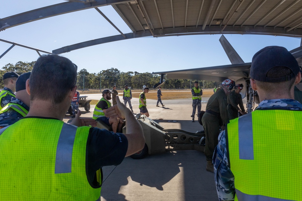 U.S. Marines and Australian Airmen load Missiles on Joint Strike Fighters together  