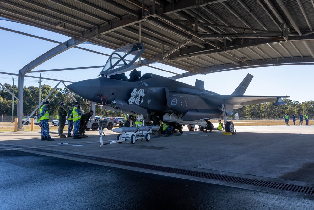 U.S. Marines and Australian Airmen load Missiles on Joint Strike Fighters together  