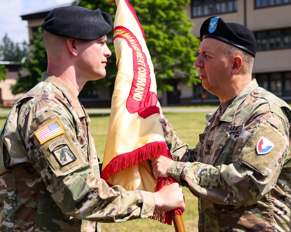 LTC Trent Colestock, outgoing Garrison Commander, passes the Garrison colors to the presiding officer, Col Mitchell Wisniewski