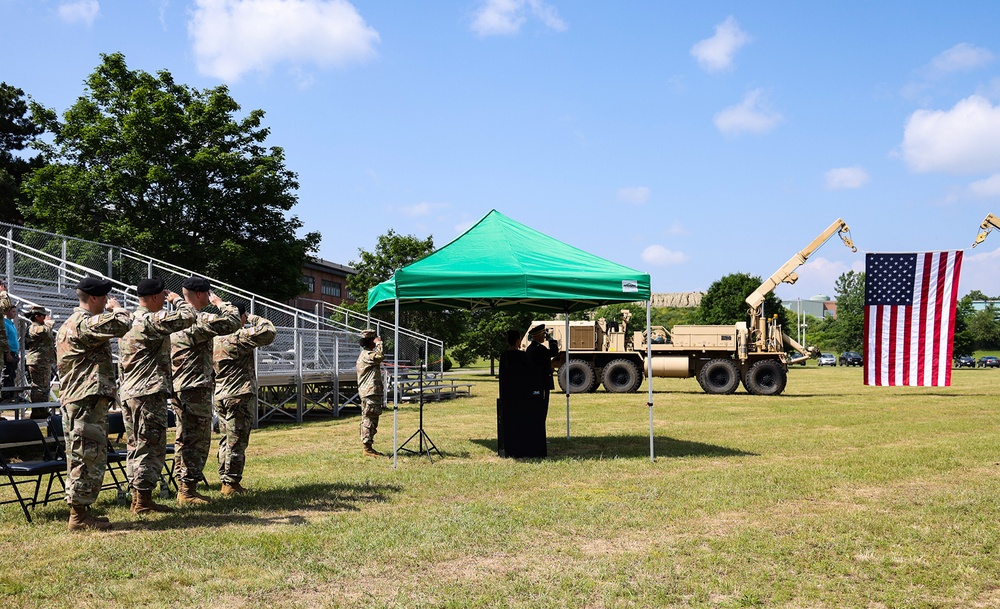 Members of the Command team and attendees at the Change of Command ceremony at Devens RFTA salute the American flag during the playing of the National Anthem on 30 June 2023.