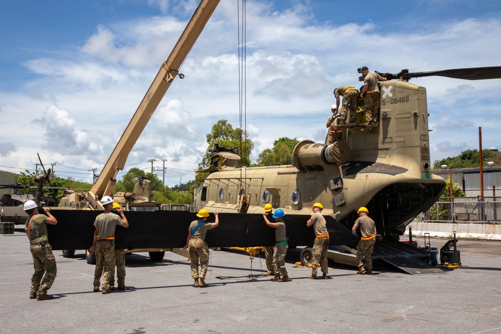 U.S. Army Soldiers of the 25th Combat Aviation Brigade coordinate to reassemble the rotor blades on a CH-47 Chinook helicopter