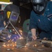 USS Ronald Reagan (CVN 76) Sailors train midshipmen how to weld and use a lathe