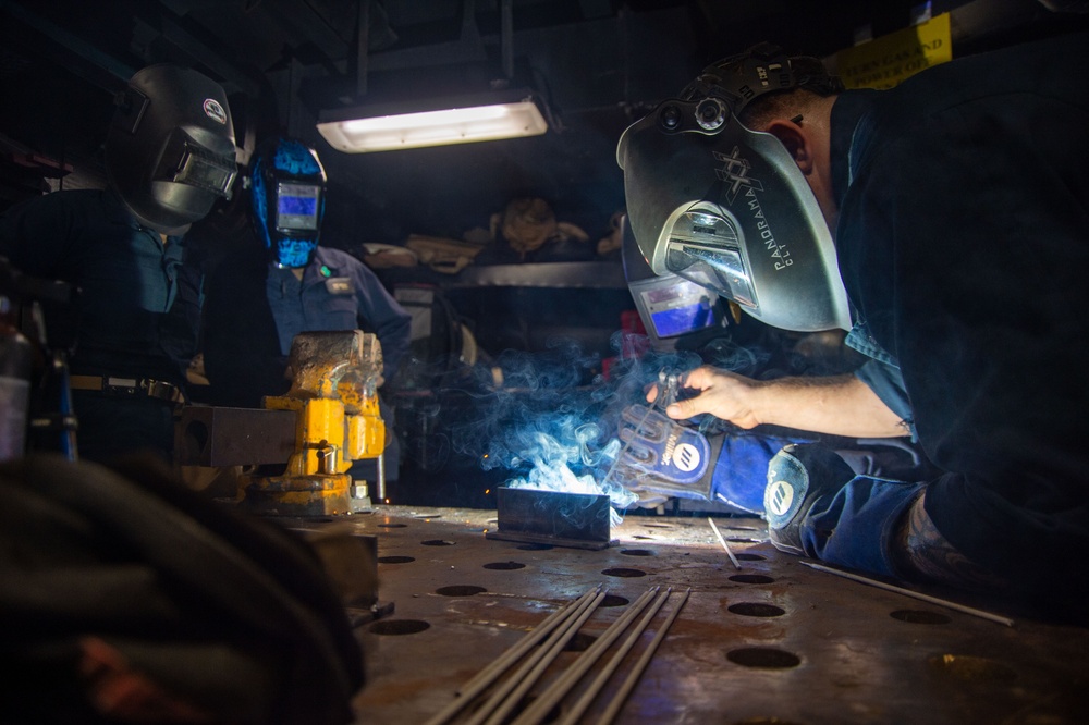 USS Ronald Reagan (CVN 76) Sailors train midshipmen how to weld and use a lathe
