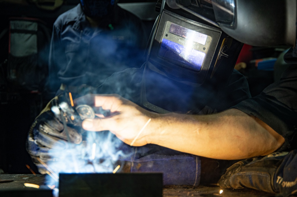 USS Ronald Reagan (CVN 76) Sailors train midshipmen how to weld and use a lathe