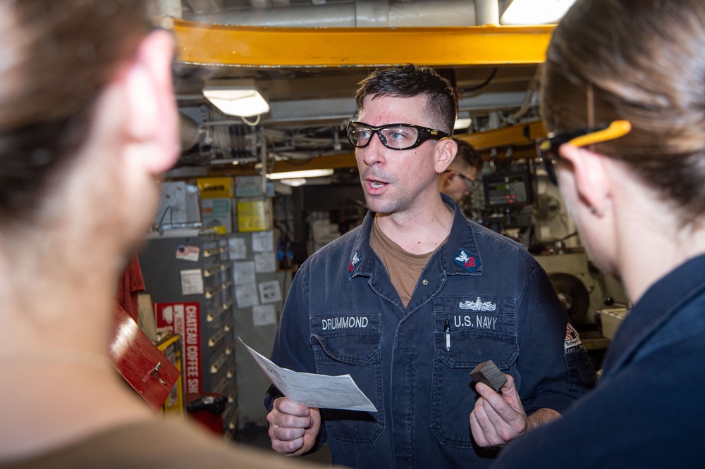 USS Ronald Reagan (CVN 76) Sailors train midshipmen how to weld and use a lathe