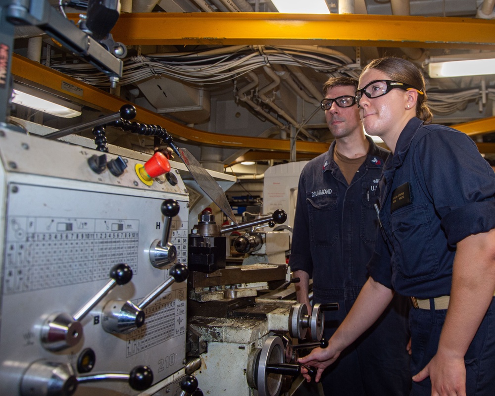 USS Ronald Reagan (CVN 76) Sailors train midshipmen how to weld and use a lathe