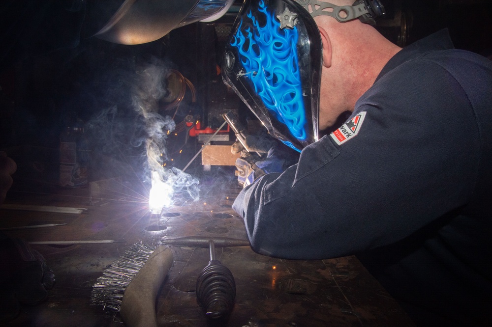 USS Ronald Reagan (CVN 76) Sailors train midshipmen how to weld and use a lathe