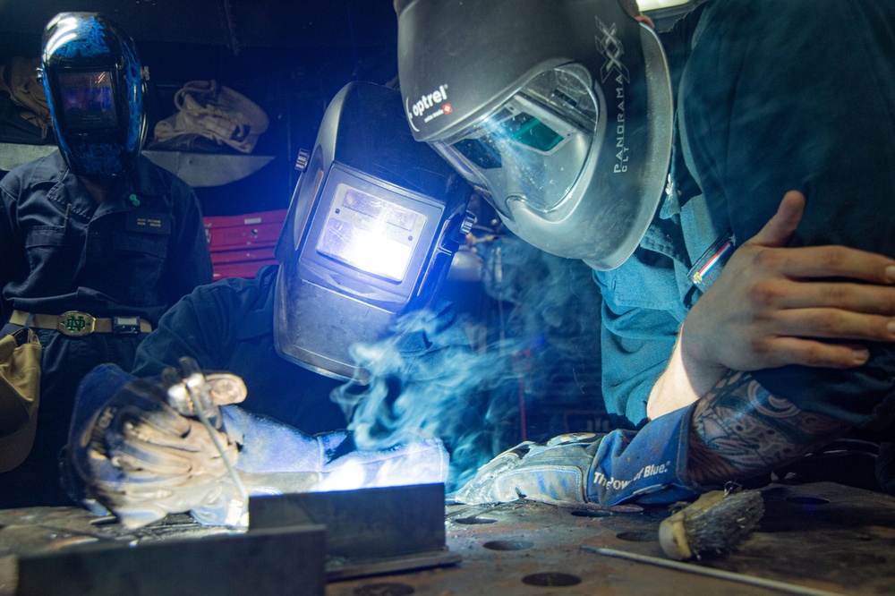 USS Ronald Reagan (CVN 76) Sailors train midshipmen how to weld and use a lathe