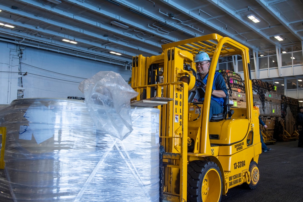 Sailors Move Supplies in the Hangar Bay of USS Carl Vinson (CVN 70)