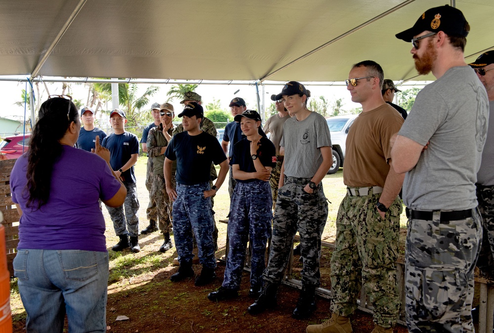 Volunteers receive direction during an international outreach project on Guam.