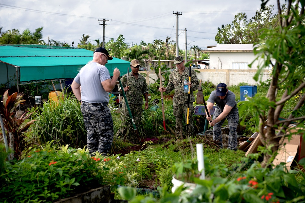 Service members from multiple nations volunteer together during an international community outreach event