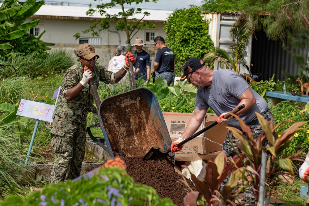 Service members from multiple nations volunteer together during an international community outreach project on Guam