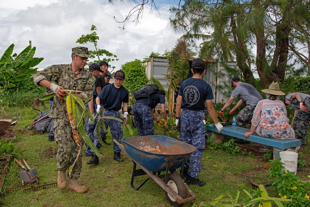 Service members from multiple navies work together during an international community relations project on Guam