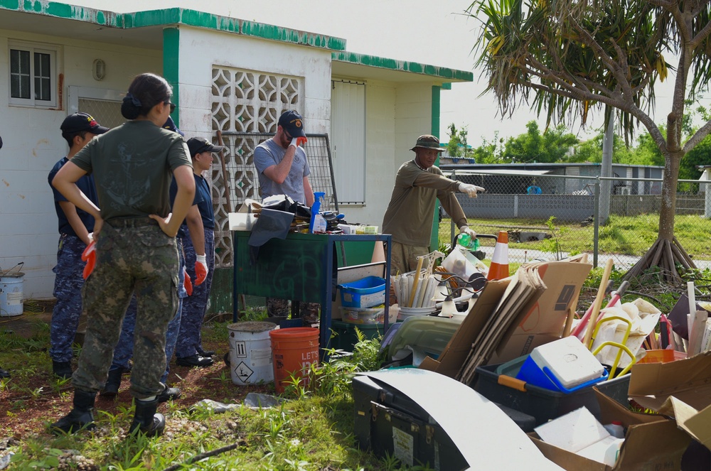 A representative of Island Girl Power directs international volunteers through typhoon debris mitigation