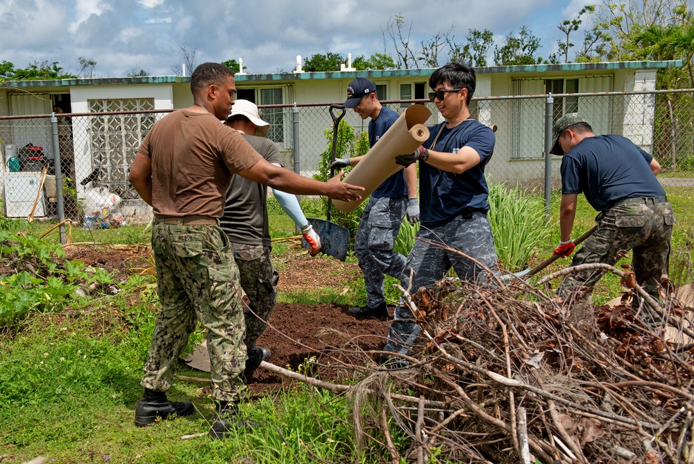 Sailors from multiple nations volunteer together during an international community outreach event