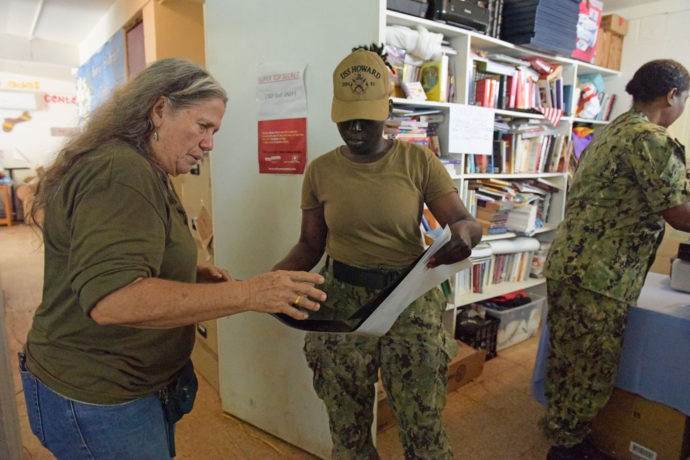 Staff at Island Girl Power provide direction to volunteer sailors during a community outreach project