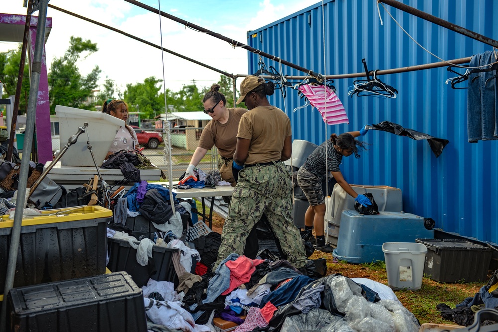 Sailors sort through typhoon-damaged goods during a volunteer project at Island Girl Power