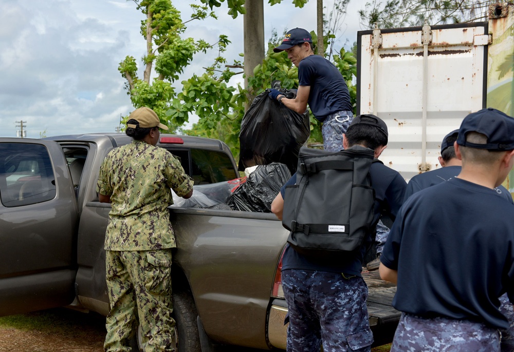 Sailors from the U.S. Navy and Japan Maritime Self-Defense Force work together to load debris during a volunteer project