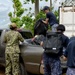 Sailors from the U.S. Navy and Japan Maritime Self-Defense Force work together to load debris during a volunteer project