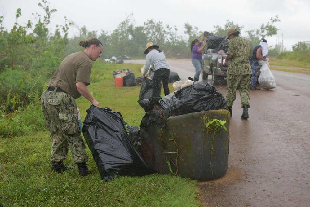 Sailors race the rain to finish loading a truck with typhoon debris