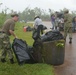 Sailors race the rain to finish loading a truck with typhoon debris