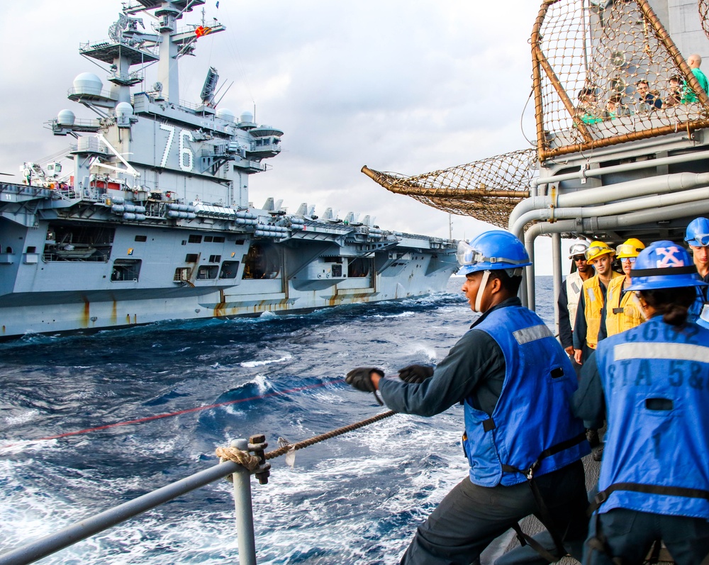 USS Robert Smalls (CG 62) Sailor Heaves Line during RAS with USS Ronald Reagan (CVN 76)