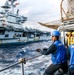 USS Robert Smalls (CG 62) Sailor Heaves Line during RAS with USS Ronald Reagan (CVN 76)