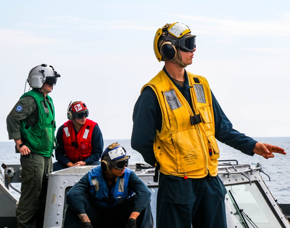 USS Robert Smalls (CG 62) Sailor Signals Pilot during Flight Quarters