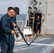 Crash and salvage team members train by fighting a simulated fire aboard USS Ralph Johnson.