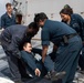 Crash and salvage team members train by fighting a simulated fire aboard USS Ralph Johnson.