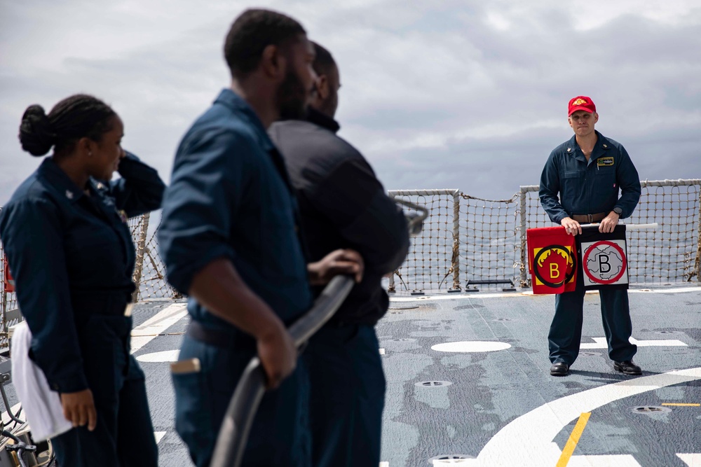 Crash and salvage team members train by fighting a simulated fire aboard USS Ralph Johnson.