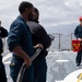 Crash and salvage team members train by fighting a simulated fire aboard USS Ralph Johnson.