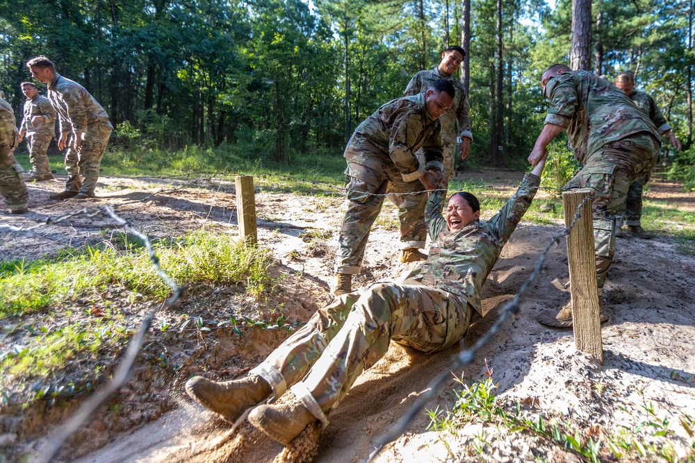 Army Staff Sgt. Emma Reos completes the low crawl wire obstacle