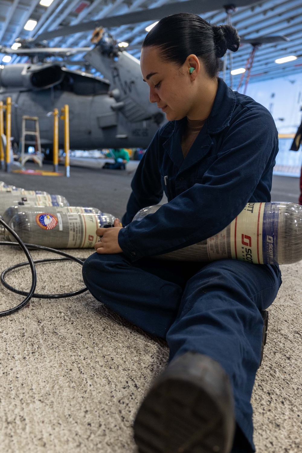 USS Bataan Sailor fills SCBAs