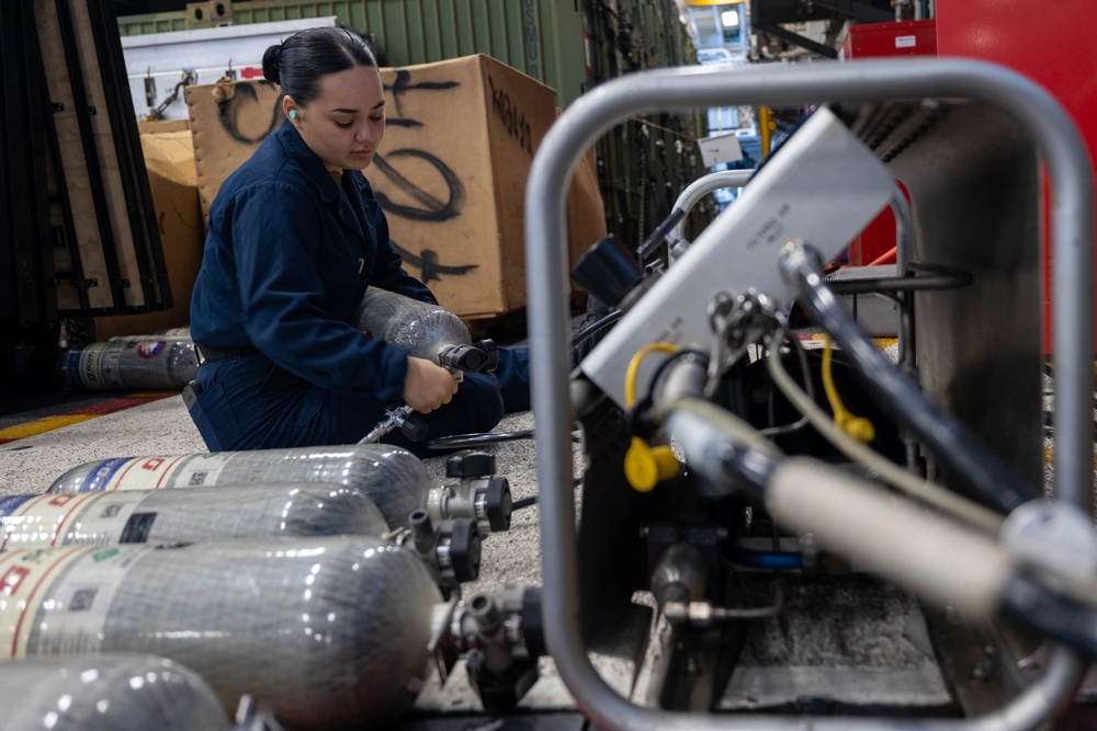 USS Bataan Sailor fills SCBAs