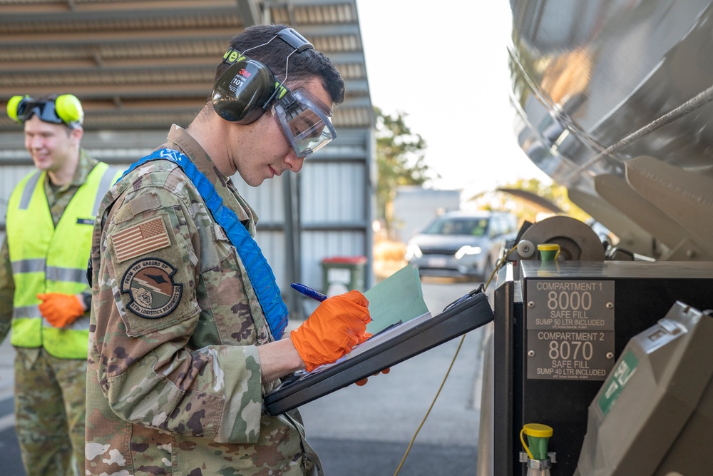 USAF Airmen and RAAF aviator refuel F-22 Raptors