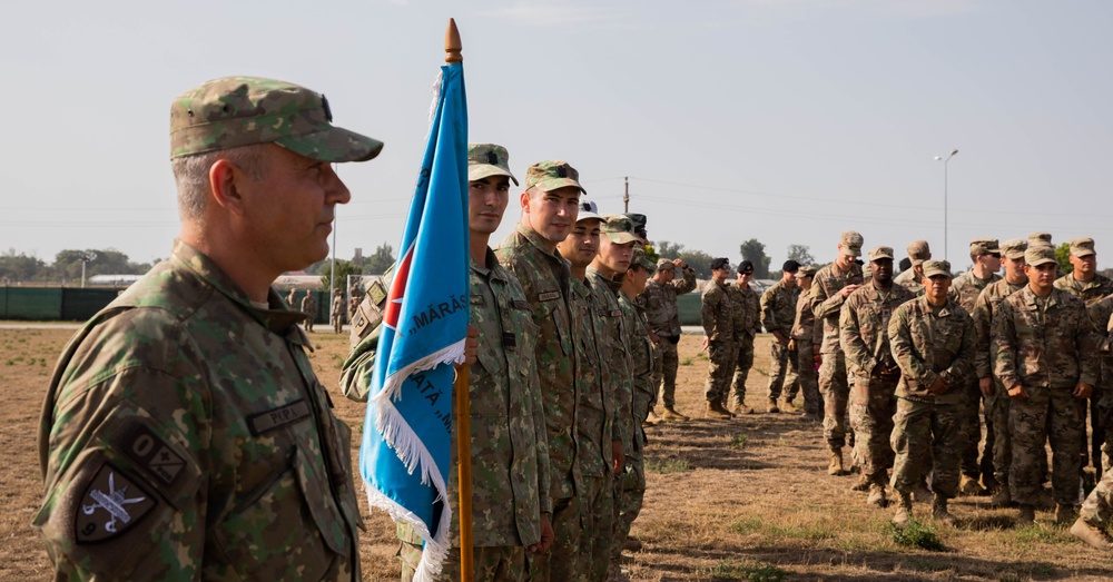 U.S. and international service members stand in formation during award ceremony