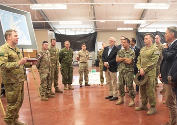 Chief of Staff Headquarters 1st (Australian) Division, Colonel Gavin Ware, briefs Secretary of Defense Lloyd J. Austin III