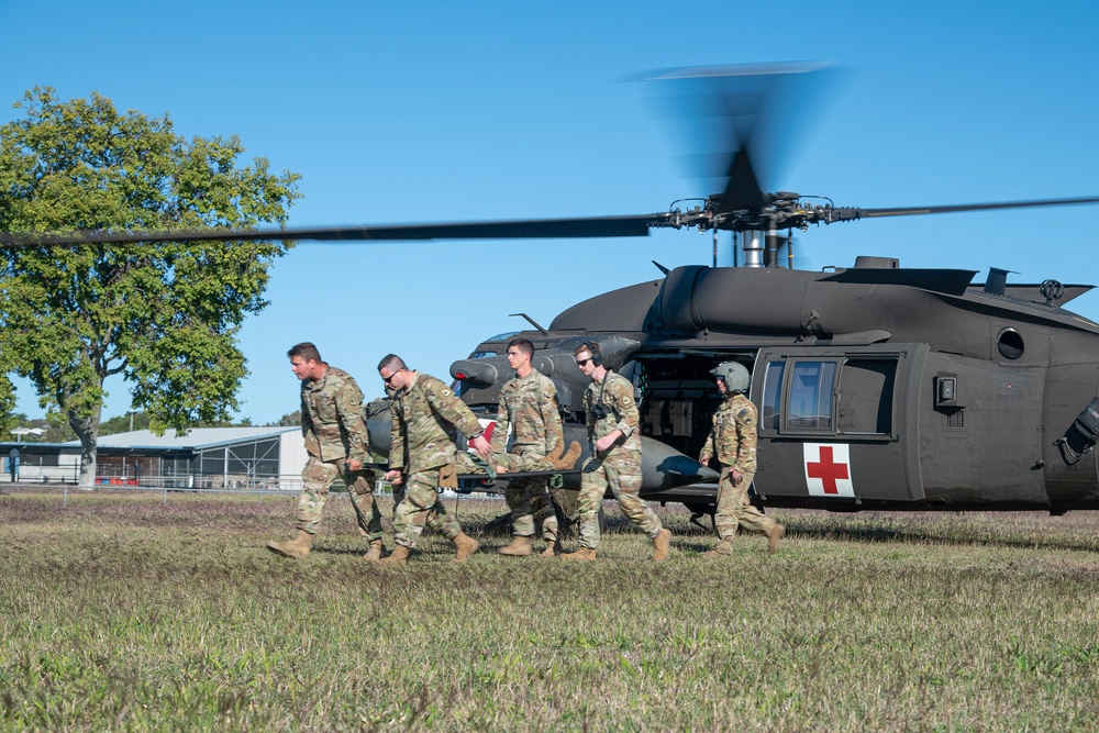 Soldiers from the 1-52nd General Support Aviation Battalion, U.S. Army, train soldiers from the 144th Area Support Company, UTANG, on medical evacuation procedures during Talisman Sabre 2023