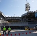 Sailors onload the aircraft crash and salvage crane onto the flight deck of Abraham Lincoln.