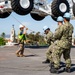 Sailors onload the aircraft crash and salvage crane onto the flight deck of Abraham Lincoln