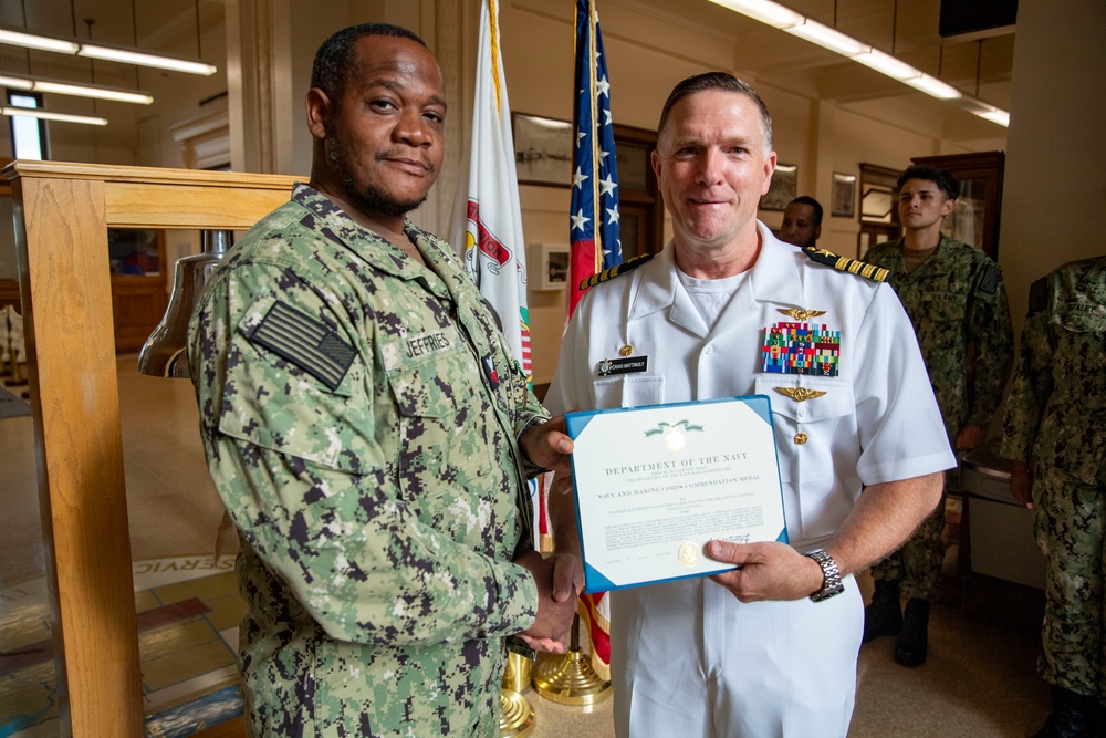 Capt. Craig Mattingly Awards Aviation Electricians Mate 1st Class Steven Jeffries Navy and Marine Corps. Commendation Medal