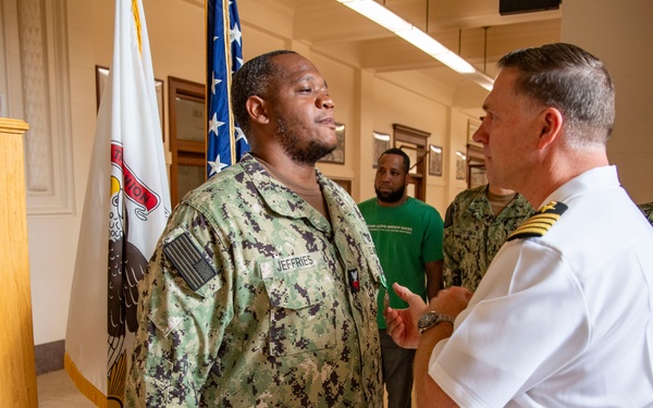 Capt. Craig Mattingly Awards Aviation Electricians Mate 1st Class Steven Jeffries Navy and Marine Corps. Commendation Medal