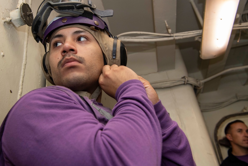 Sailor dons safety gear during replenishment at sea