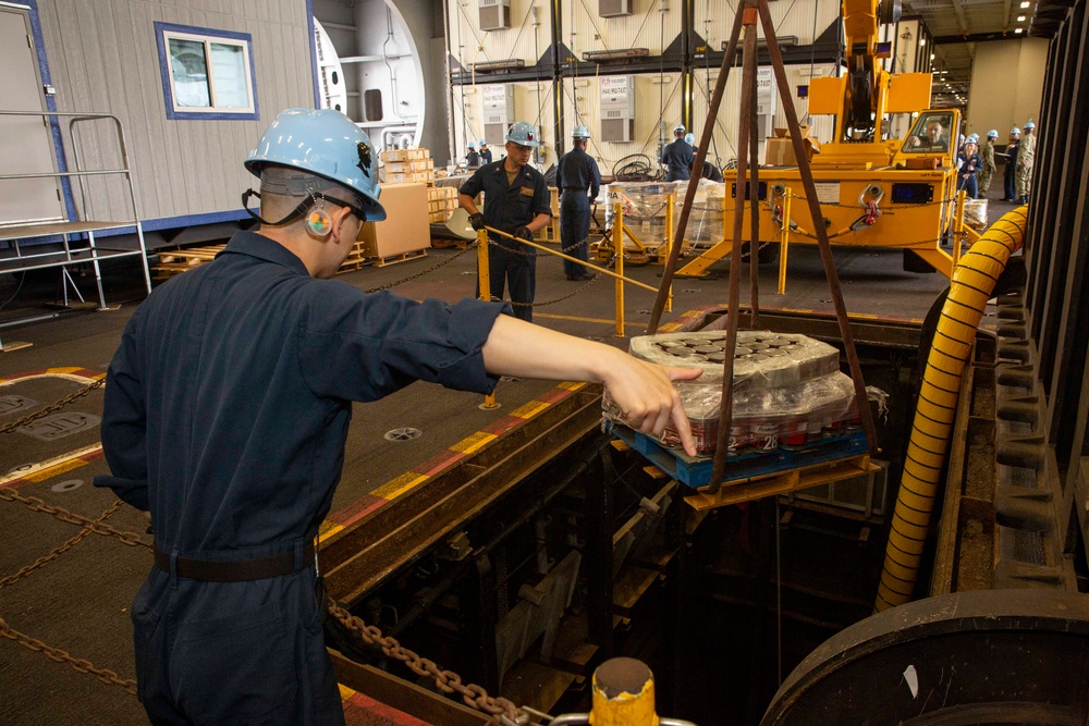 Sailors onload hazardous materials onto Abraham Lincoln